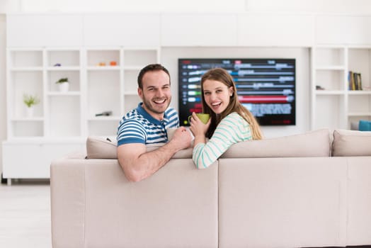 young beautiful handsome couple enjoying morning coffee at home