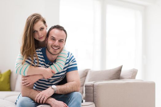 young handsome couple enjoys hugging on the sofa in their luxury home villa