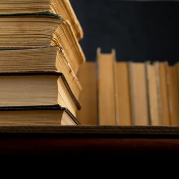 Collection of old books on wooden background. Book in the library. Bookshelf shop. Knowledge publications, literature. Bookish bookstore, bookshop. Booklover.