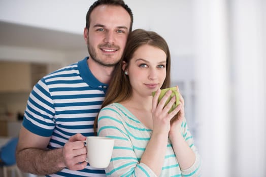 young beautiful handsome couple enjoying morning coffee at home