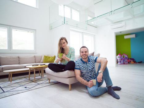 young beautiful handsome couple enjoying morning coffee at home