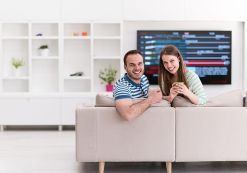 young beautiful handsome couple enjoying morning coffee at home