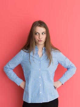 Portrait of a beautiful positive young woman while playing with her long silky hair isolated on red background