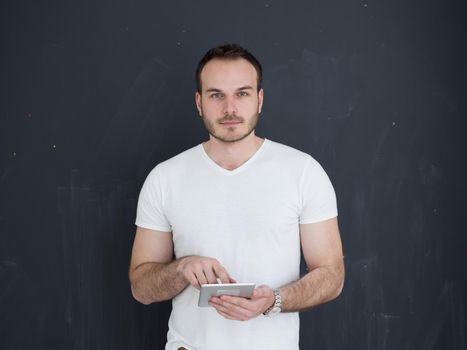 Happy young man using tablet computer isolated over gray background