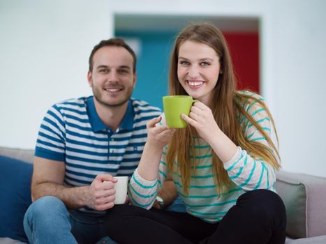 young beautiful handsome couple enjoying morning coffee at home