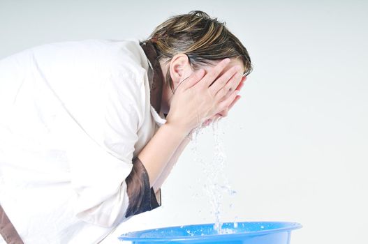 bautiful young woman wash face with clean water isolated on white in studio