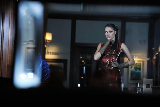 beautiful young woman lady in fashion dress posing in restaurant or bar at night