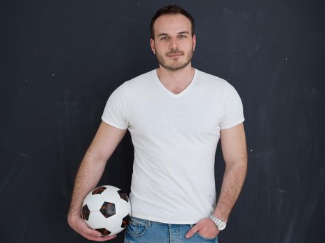 young handsome man playing with soccer ball isolated over grey background
