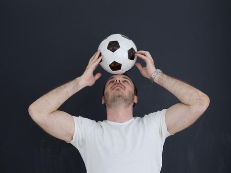 young handsome man playing with soccer ball isolated over grey background