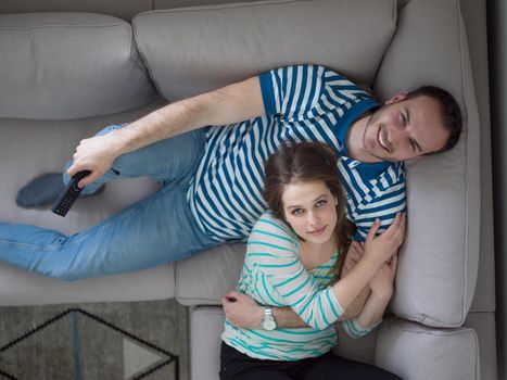 young handsome couple enjoys hugging on the sofa in their luxury home villa