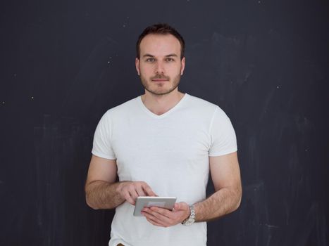 Happy young man using tablet computer isolated over gray background