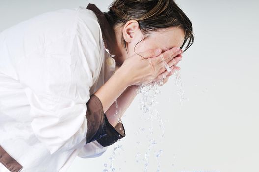bautiful young woman wash face with clean water isolated on white in studio