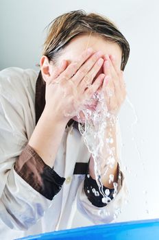 bautiful young woman wash face with clean water isolated on white in studio