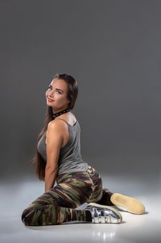 Attractive young blonde woman in the studio dancing Booty dance on a pink background. Dancer. Modern dance styles