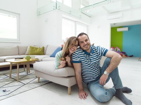 young handsome couple enjoys hugging on the sofa in their luxury home villa