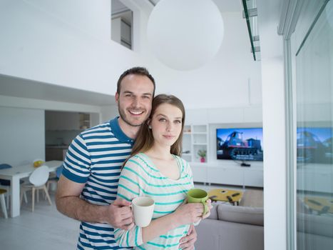 young beautiful handsome couple enjoying morning coffee at home