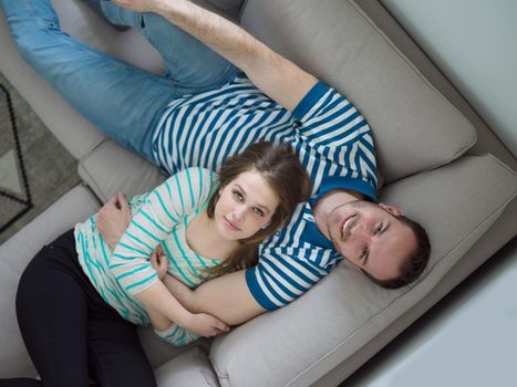 young handsome couple enjoys hugging on the sofa in their luxury home villa