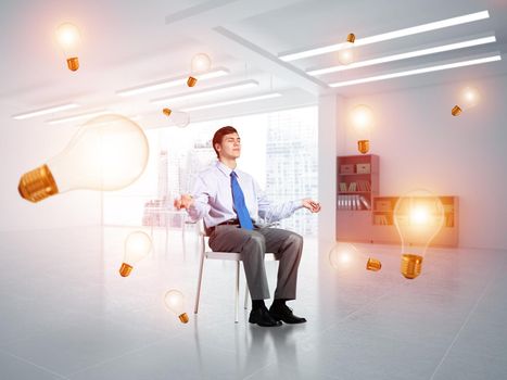 young businessman in the office meditates. concept of creativity