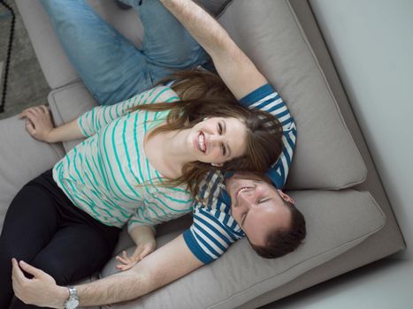 young handsome couple enjoys hugging on the sofa in their luxury home villa