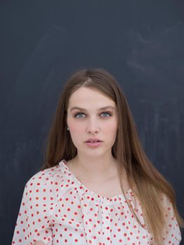 beautiful young woman celebrating new year and chrismas party while blowing confetti decorations to camera isolated over gray background