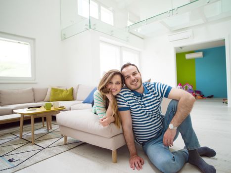 young handsome couple enjoys hugging on the sofa in their luxury home villa