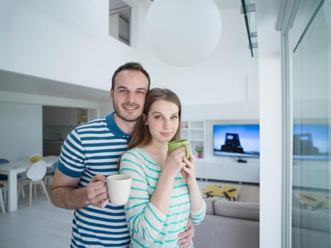 young beautiful handsome couple enjoying morning coffee at home