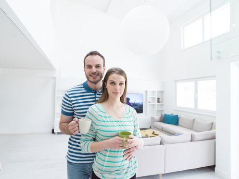 young beautiful handsome couple enjoying morning coffee at home