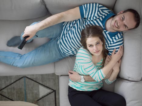 young handsome couple enjoys hugging on the sofa in their luxury home villa