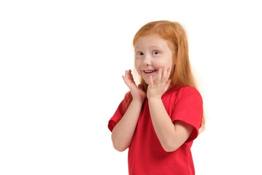 What a surprise. Pleasant cute upbeat little girl holding her hands near face and smiling while expressing joy.