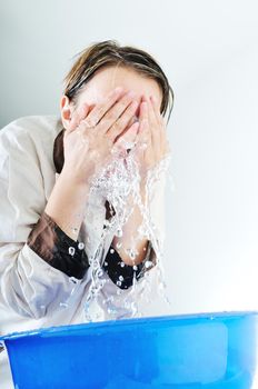 bautiful young woman wash face with clean water isolated on white in studio