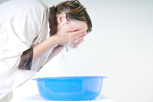 bautiful young woman wash face with clean water isolated on white in studio