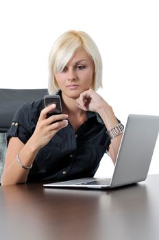 One young business blonde woman working in office on laptop and talking on cellphone, isolated image