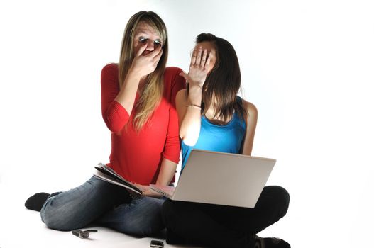 scared and shocked two young woman isolated looking in laptop