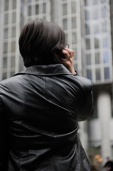young business woman talking by phone on street