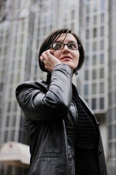 young business woman talking by phone on street