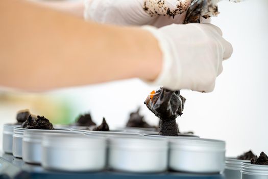 filling molds with hand-made natural organic cosmetics.