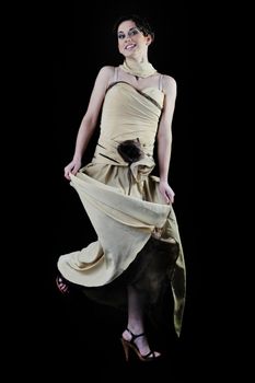  young woman in beautiful luxury dress in studio against black background in dark representing nightlife and fashion concept