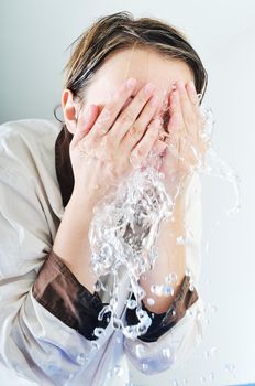 bautiful young woman wash face with clean water isolated on white in studio