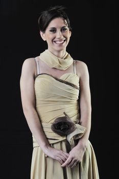  young woman in beautiful luxury dress in studio against black background in dark representing nightlife and fashion concept