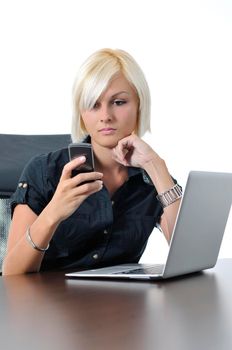 One young business blonde woman working in office on laptop and talking on cellphone, isolated image