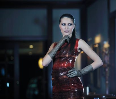 beautiful young woman lady in fashion dress posing in restaurant or bar at night