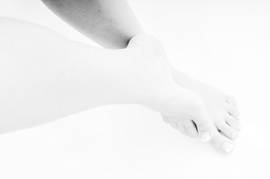 young woman bare foot with makeup nails islated on white