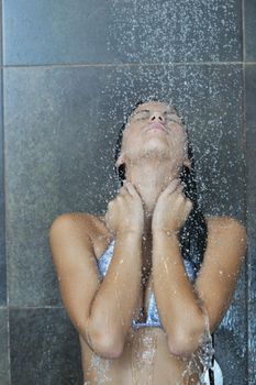 Portrait of a sexy young woman enjoing bath under water shower