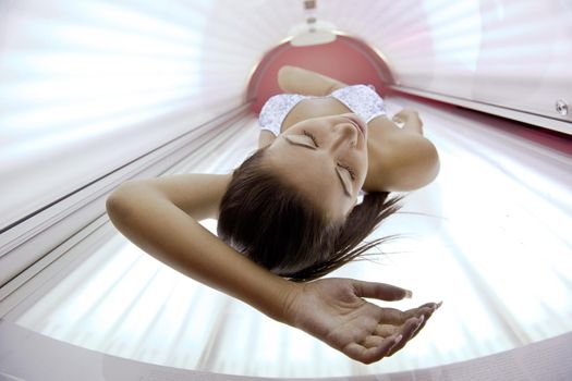 Beautiful young woman have tanning skin treatment in modern solarium