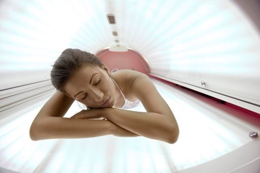 Beautiful young woman have tanning skin treatment in modern solarium