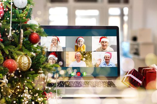 video call with happy diverse children on laptop computer in his workshop. Self-isolation and virtual online celebration at home concept. Christmas.