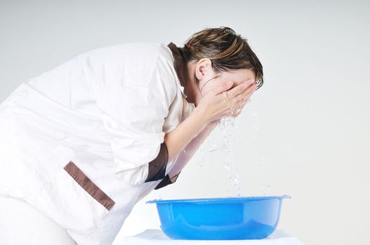 bautiful young woman wash face with clean water isolated on white in studio