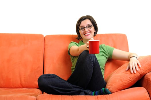 two young woman isolated on white with cup off coffee talking and chating isolated on whtie on orange sofa