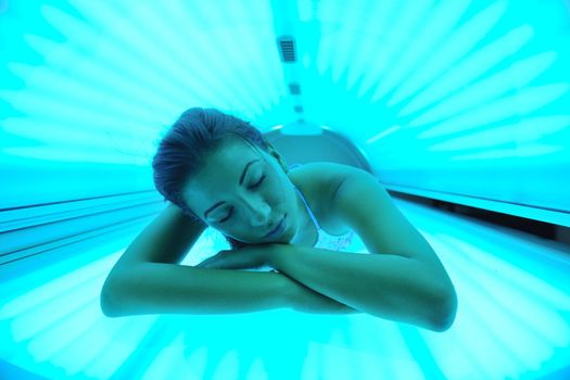 Beautiful young woman have tanning skin treatment in modern solarium