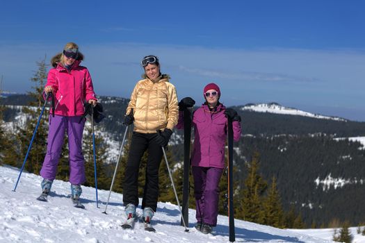 happy friends group of woman girls have fun at winter season at beautiful sunny  snow day with blue sky in background